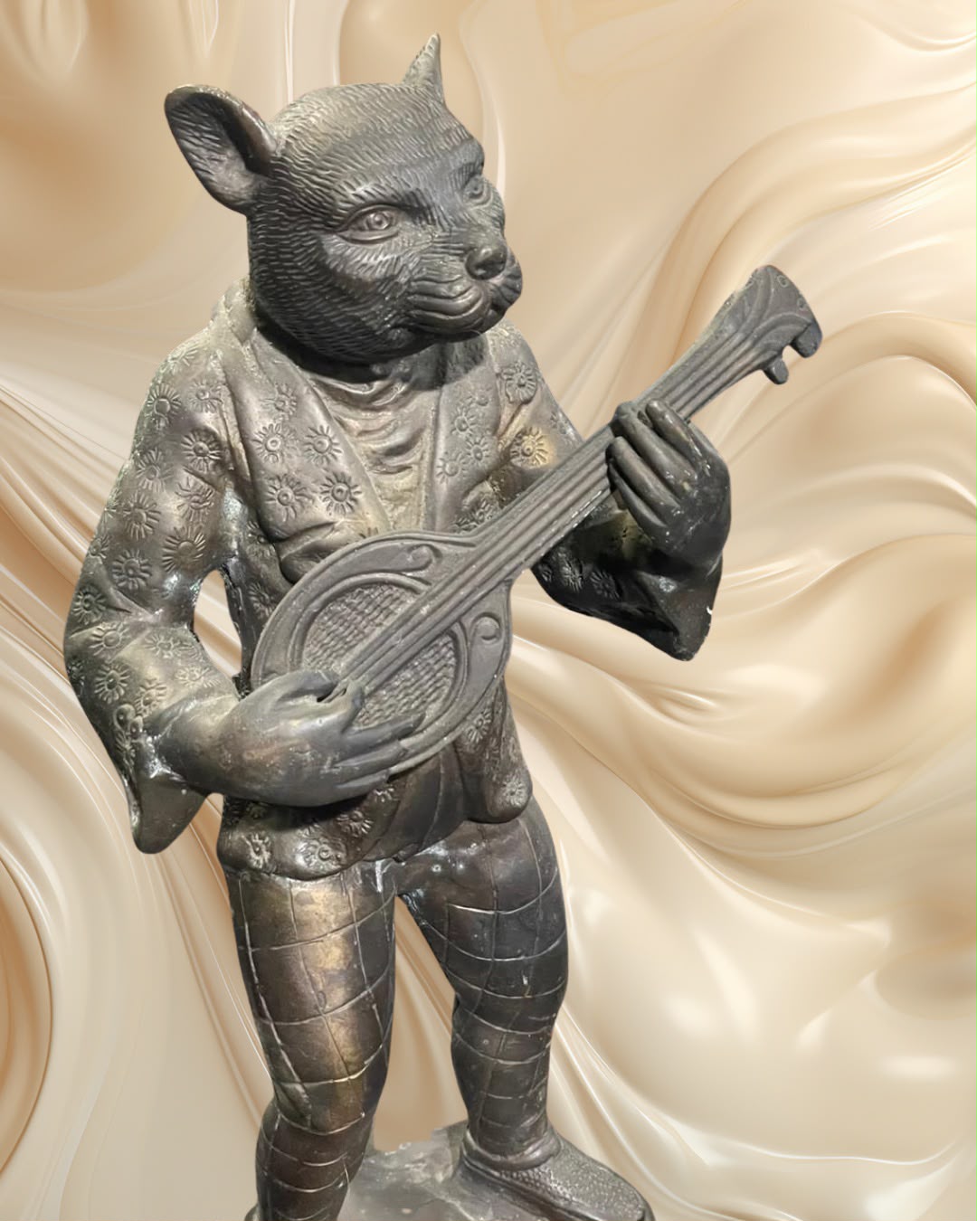 Par de esculturas em bronze representando um coelho e um gato músicos.