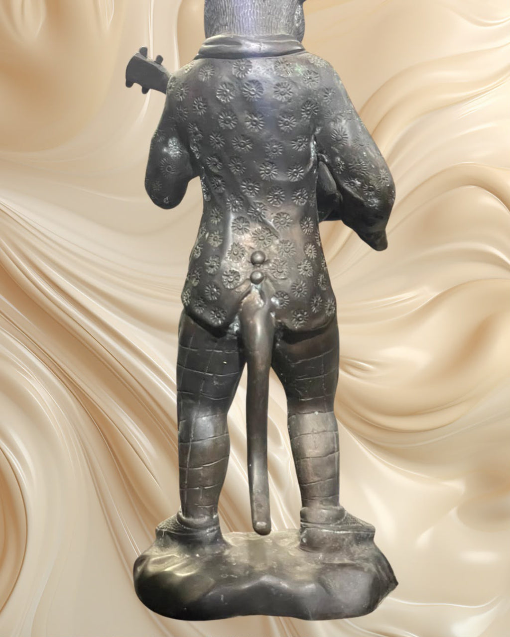 Par de esculturas em bronze representando um coelho e um gato músicos.