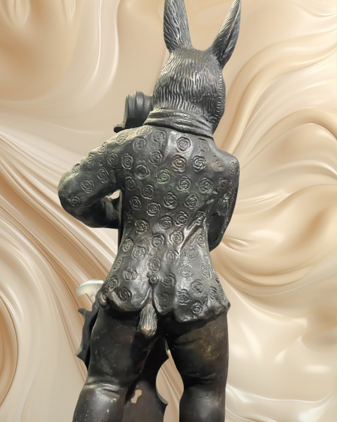 Par de esculturas em bronze representando um coelho e um gato músicos.